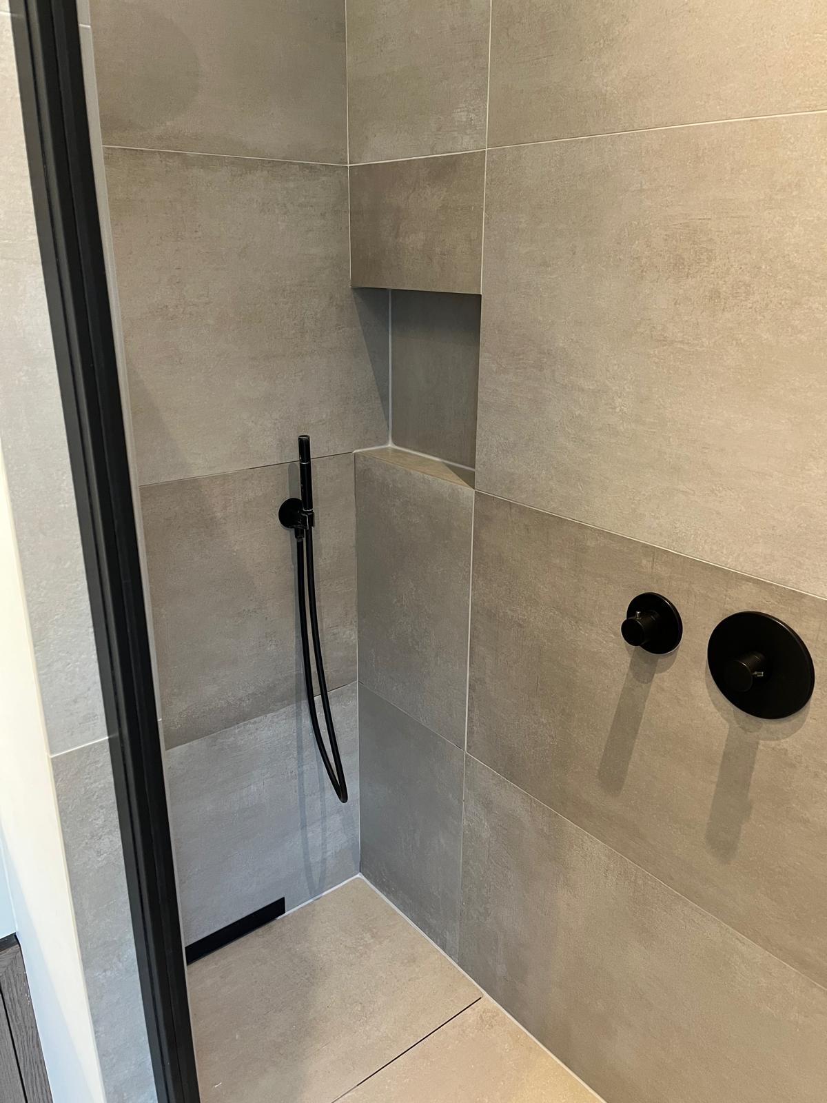 Badkamer met betegelde douchehoek